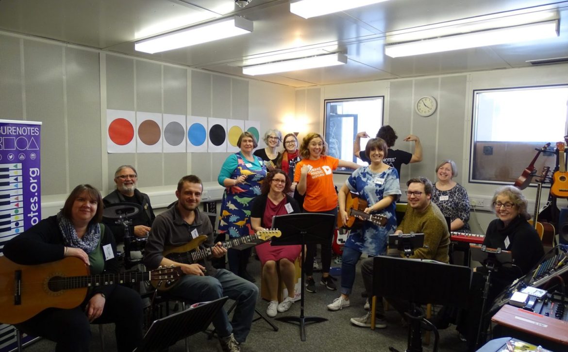 A group of trainees posing with instruments such as guitars and keyboards