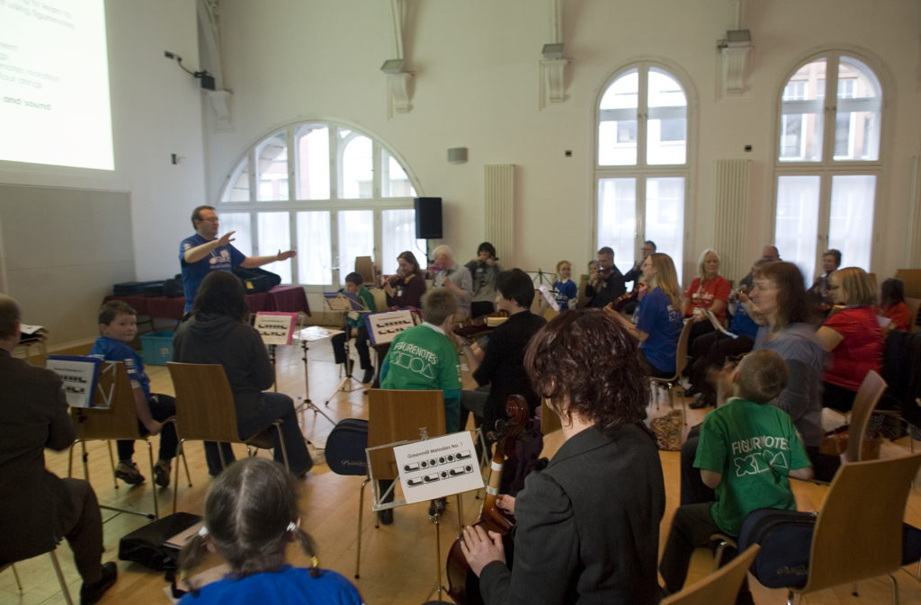 A string orchestra of young children with a conductor