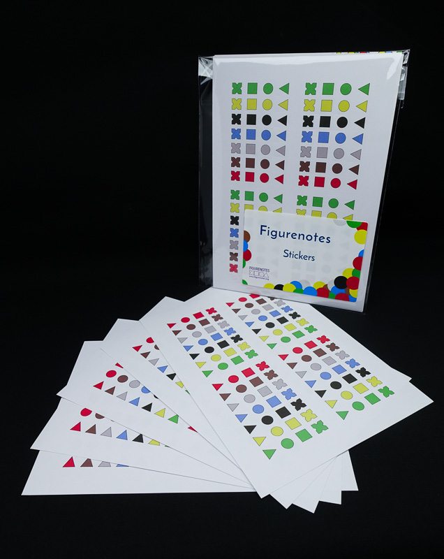 Figurenotes stickers fanned out. Another pack sits packaged behind them.